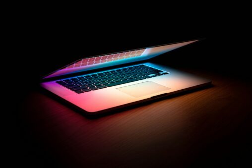 Laptop with colorful lighting on a desk, representing a computer workspace for coding or data analysis.