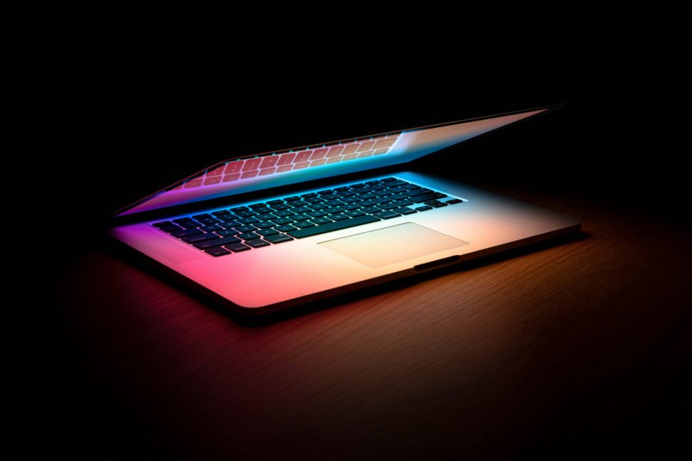 Laptop with colorful lighting on a desk, representing a computer workspace for coding or data analysis.