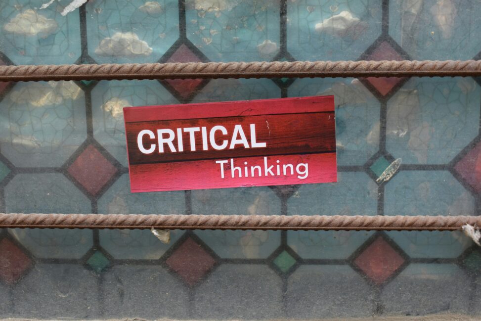 A sign that says “critical thinking” on a red background.